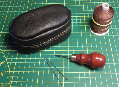 Sewing supplies, needles, thread and  an awl Sewing supplies, needles, thread and  an awl