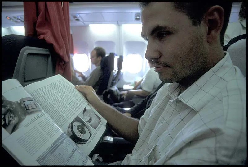 Plane litterature - Kasper preparing for the purchase of a digital camera while in the US. German photo magazines make good airplane litterature.