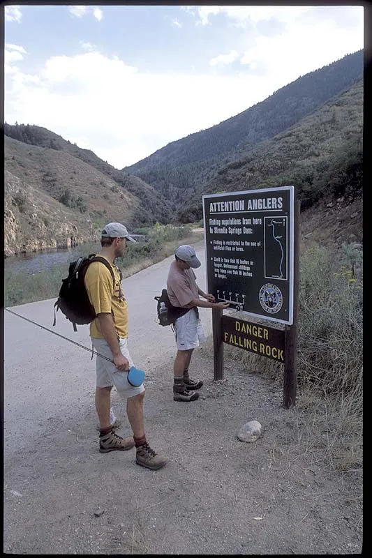 Measure check - Steve checks his rod against the meaure on the sign in order to have an indication of the length of the fish he plans to catch in Waterton Canyon.