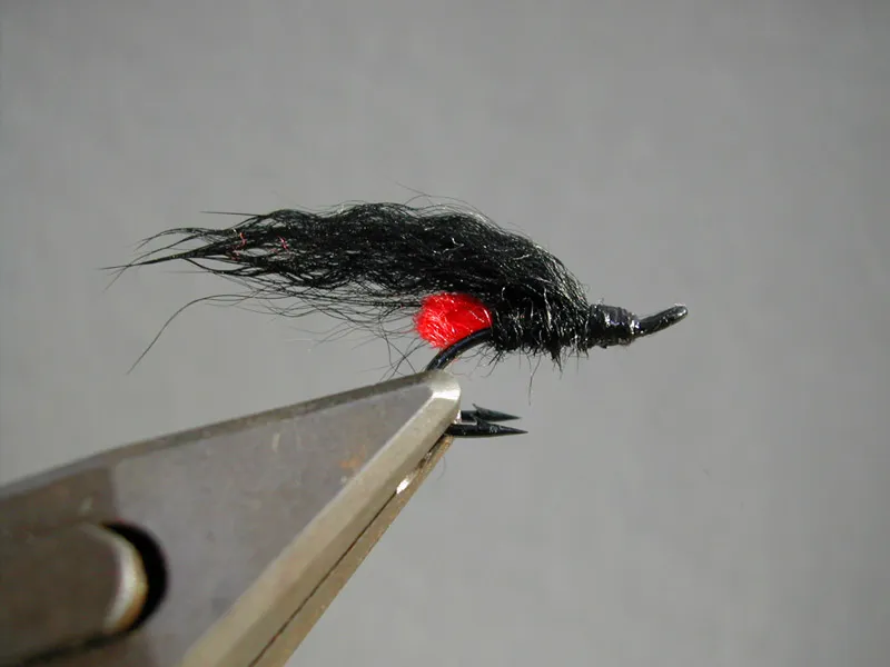 Red Tag... ehr, Butt... eee... Behind - A mini version of a generic pattern that must have caught salmon on all the northern hemisphere. This one is tied on a small size 10 double salmon hook and has a fairly long wing to compensate for its tiny size.