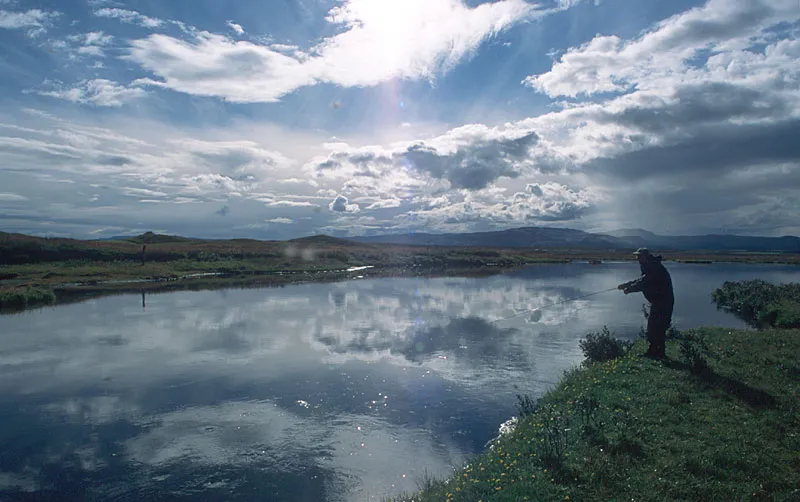Perfect sky - This is the same scene as the picture with the very bright sky. Here the angler may just be a silhuette, but the sky and the clouds - and their reflections - makes the image fine anyway. All obtained through underexposure.