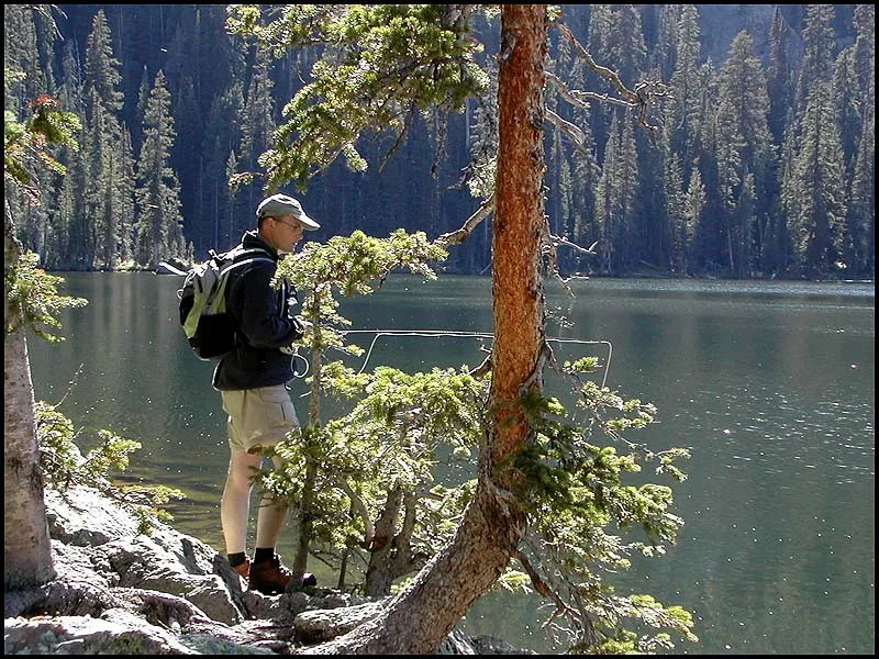 Comfortable fishing - Fishing a mountain lake like this takes place from the bank. The trees around and behind Martin show that the long backcasts are often impossible, which will limit your reach onto the lake. Many fish will cruise close by the bank, so fret not...