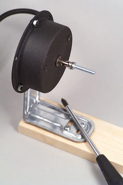 The mount - The angle bracket is secured to the wood scrap with a couple of short screws, and the motor to the iron with a short bolt.