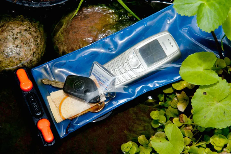 Dry bag - You can buy bags that seal 100% meant for fishing, diving, hunting and other rough outdoors activities. Such a bag will hold phone, car keys, money, ID-papers and other things that need protection, and can be worn fully exposed with no risk. This one is from <a href=\"http://store.aquapac.net/\">AquaPac</a>