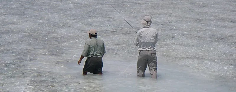 On the flats - Guide and angler wading the flats, scouting
